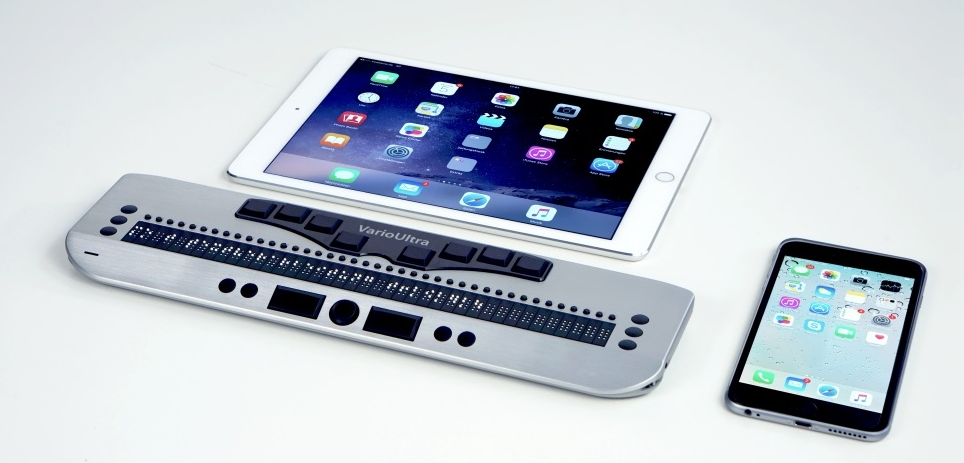 Das Bild zeigt die Braillezeile VarioUltra40 von VisioBraille in Verbindung mit iPad und iPhone.